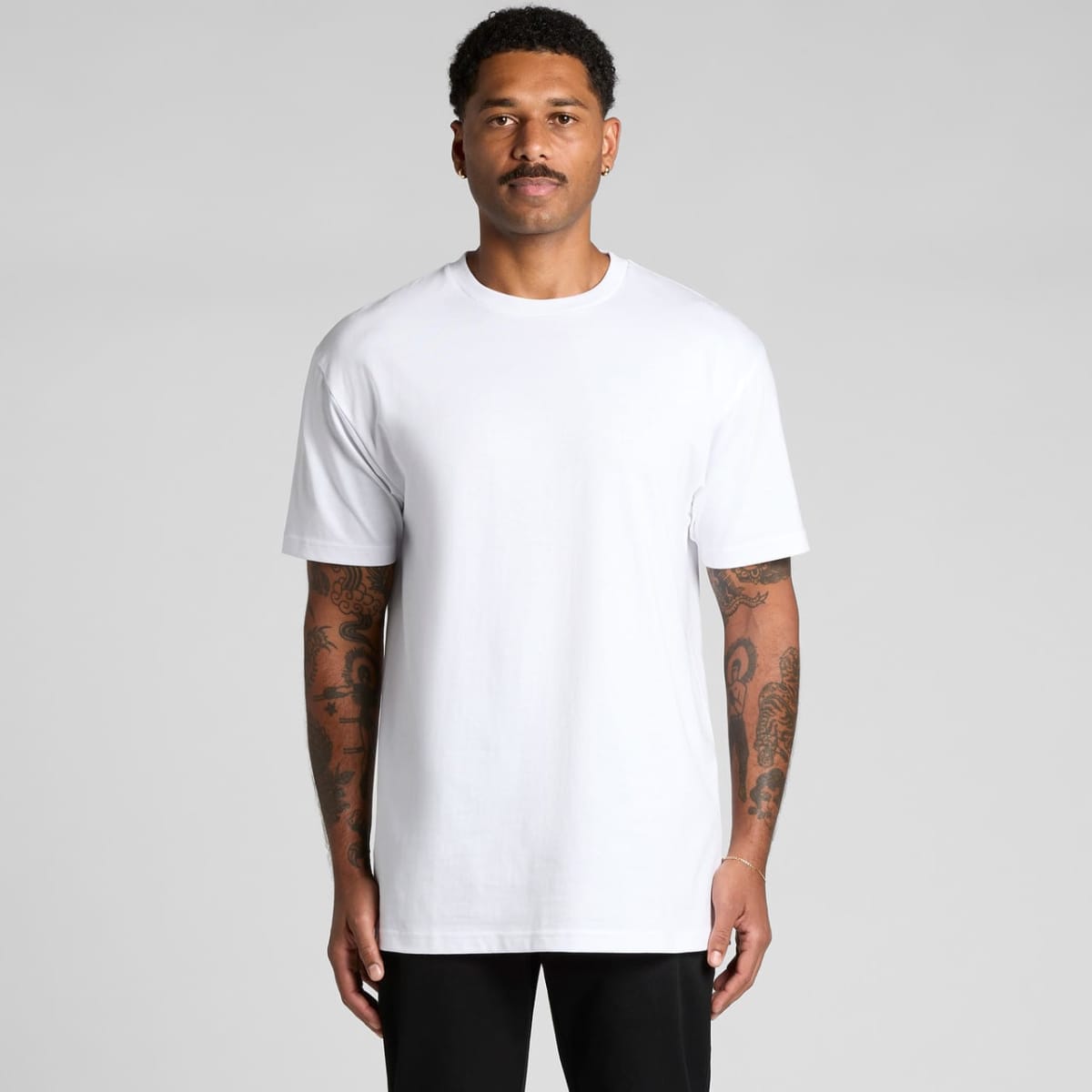 A man wearing a plain white Block Tubular Tee. The shirt is short-sleeved and has a simple design.