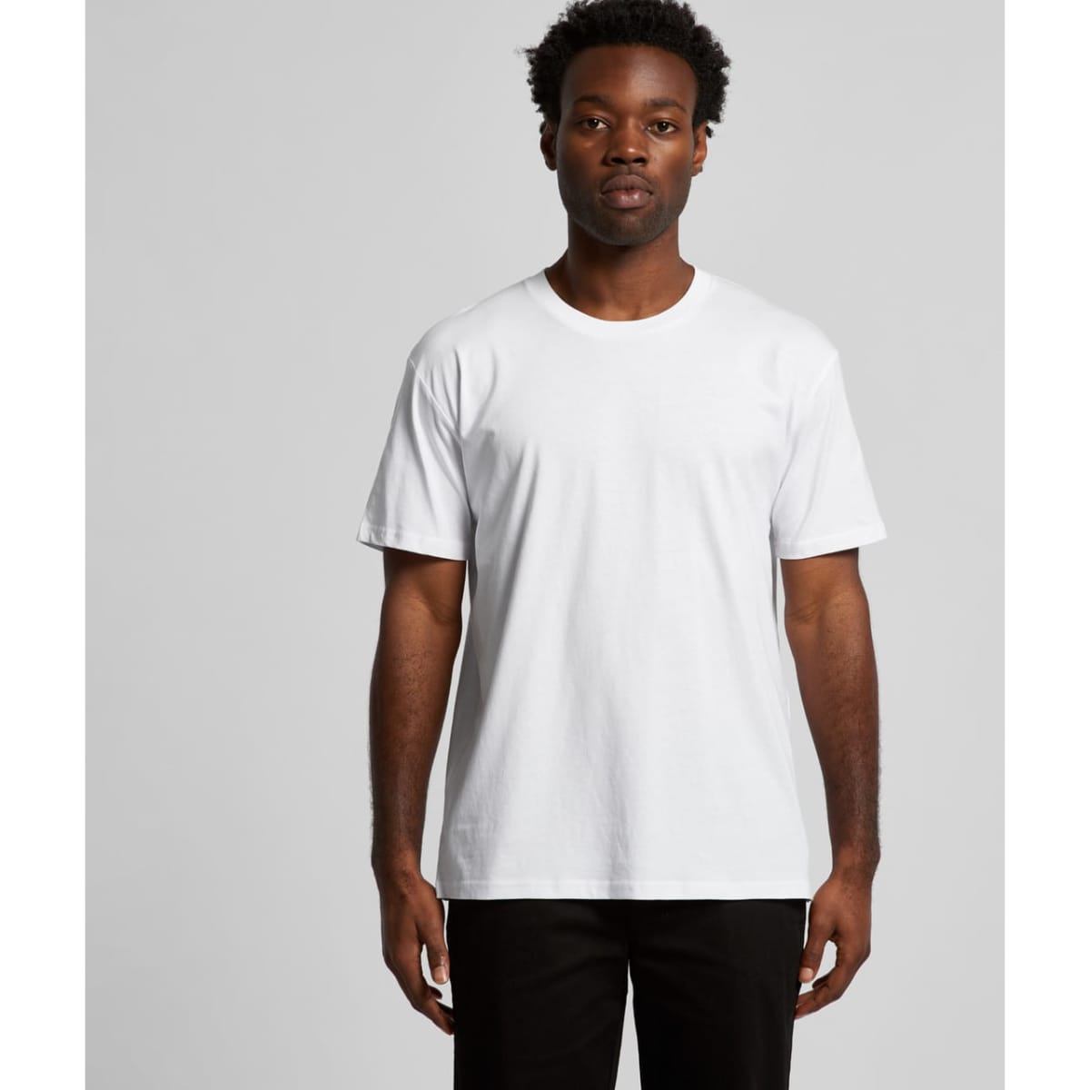 A white t-shirt with short sleeves displayed on a model against a plain backdrop. The shirt has a logo.