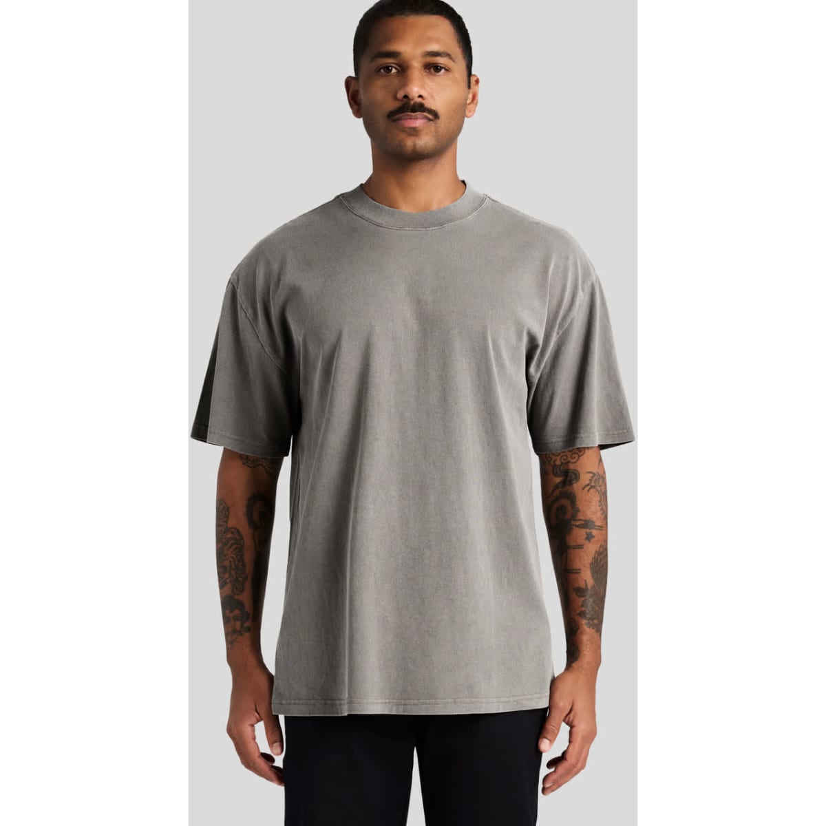 A grey heavy faded t-shirt featuring a relaxed fit and short sleeves, worn by a model.