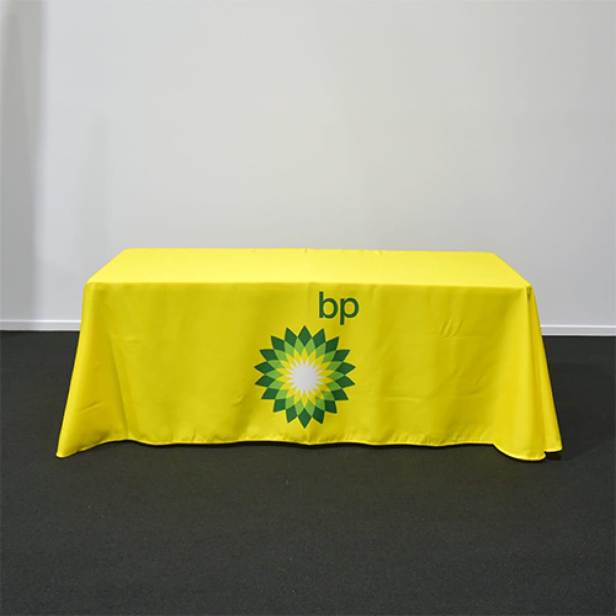 A yellow table cover featuring a logo, designed to fit over a standard table for promotional use.