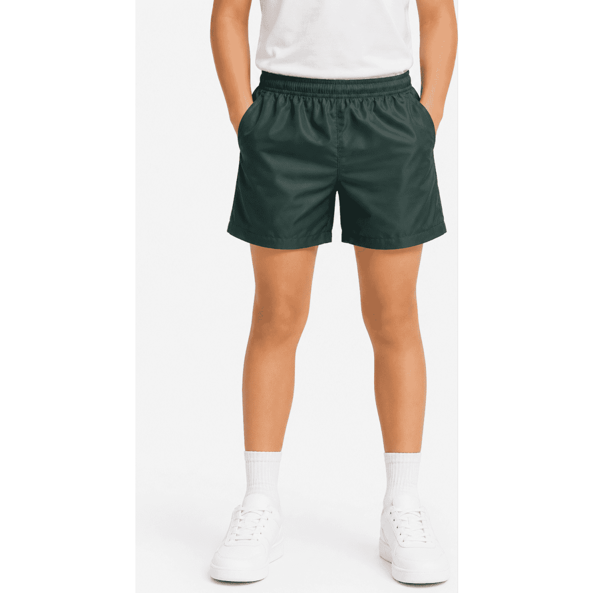 Kids' sports shorts in dark green with an elastic waistband and side pockets, paired with white shoes and socks.