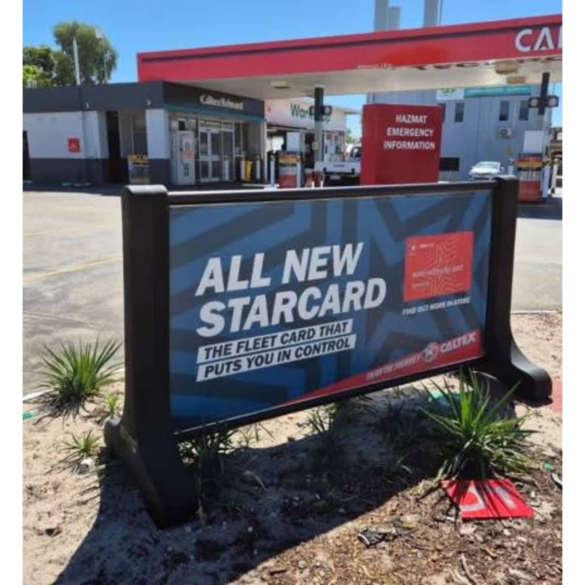 A signage barrier in black with a vibrant blue and red promotional display, featuring a branding logo.