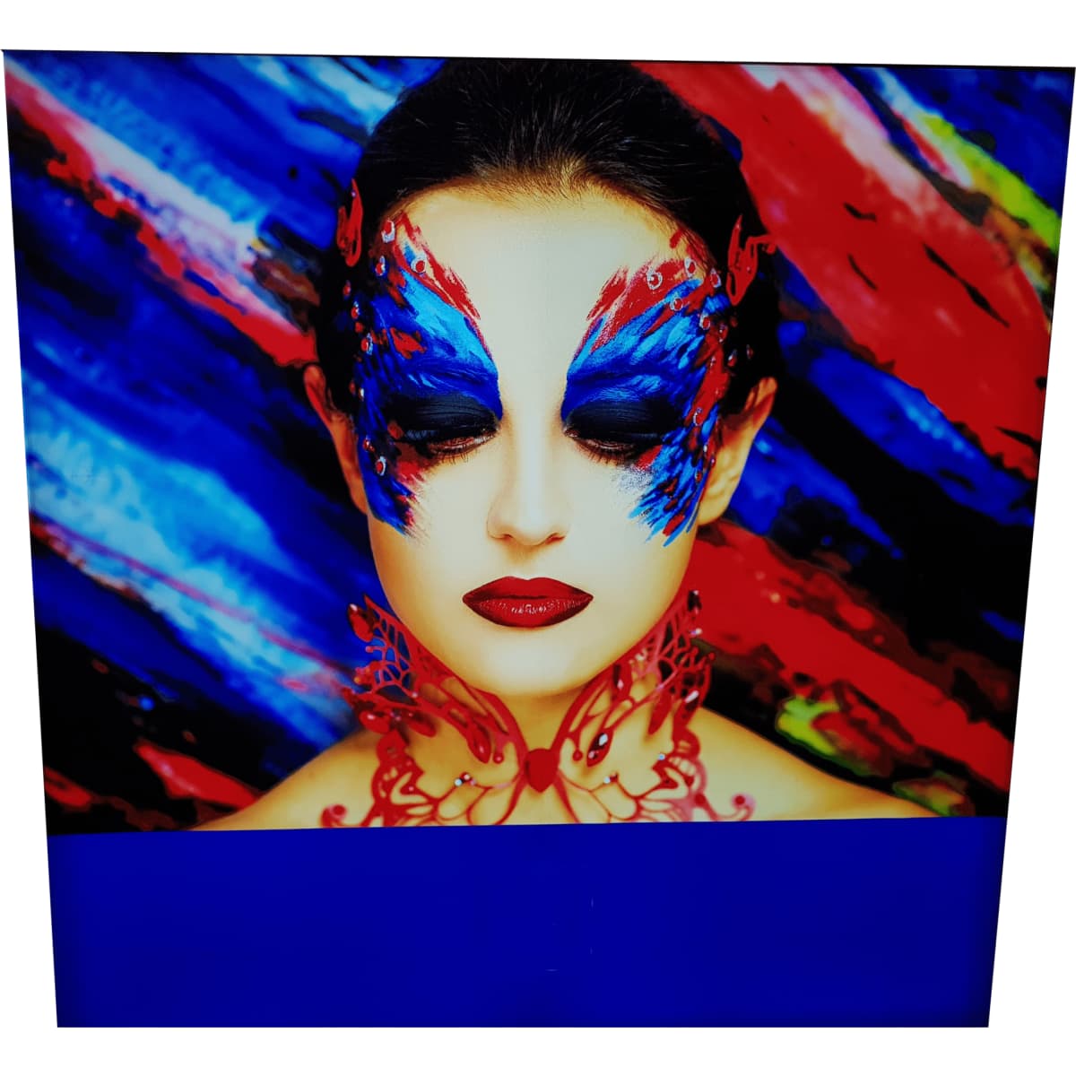 A decorative light box featuring a woman with vibrant blue and red face paint against a colourful, abstract background.