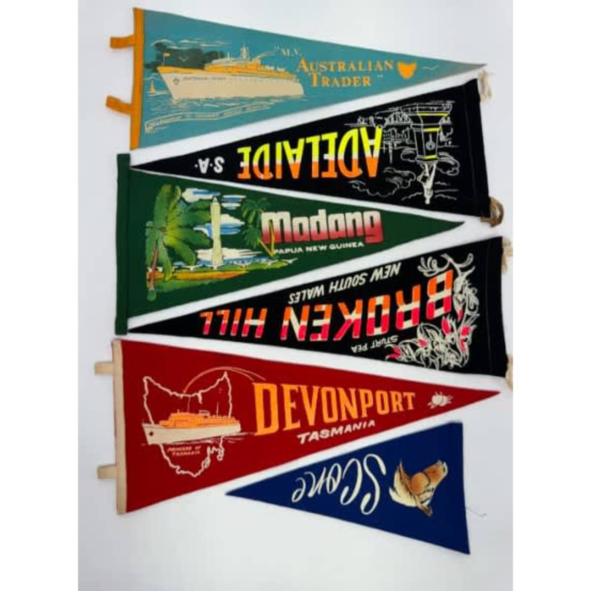 Felt pennants in various colours featuring illustrations and text from different locations and events.
