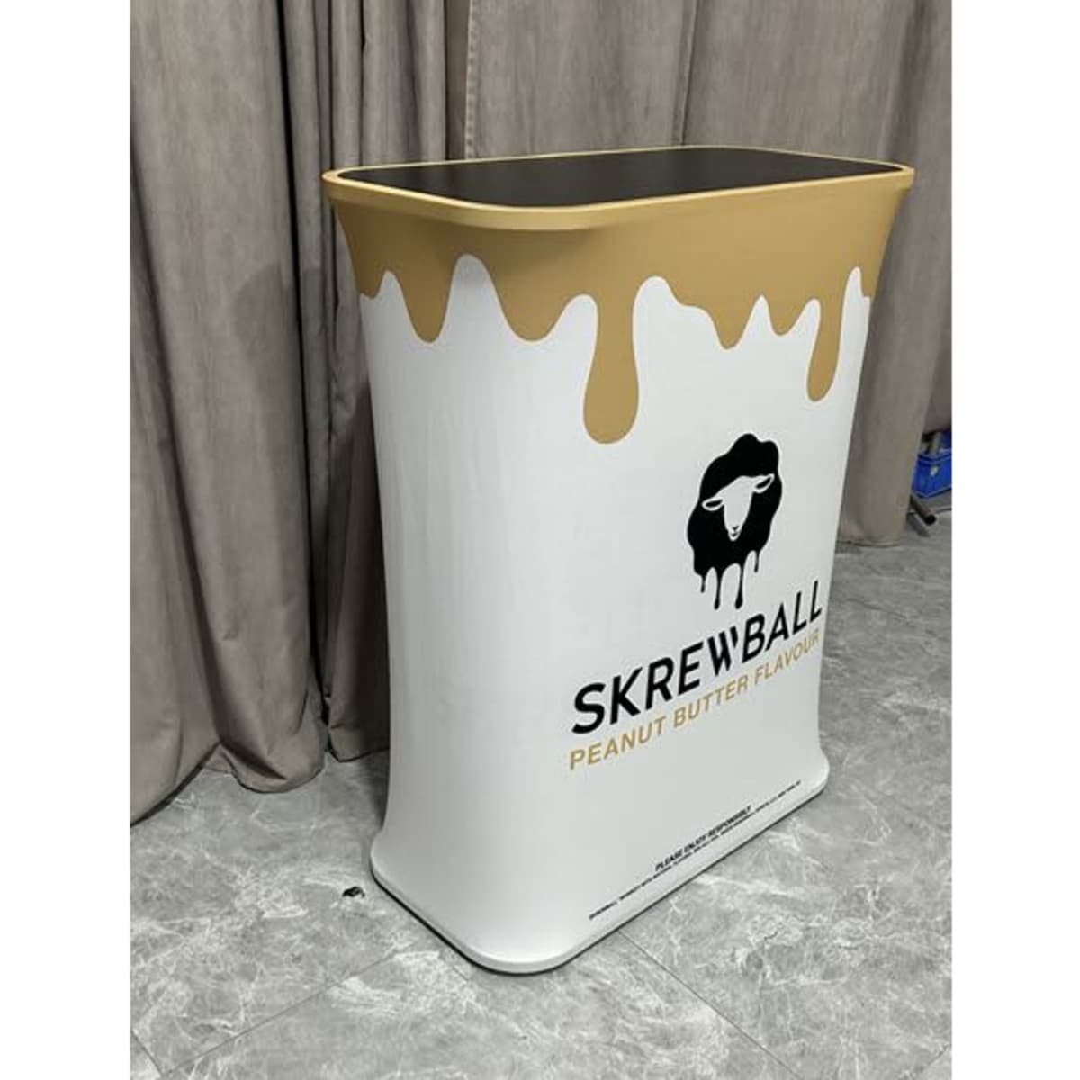A stretch fabric light box counter in white and gold, featuring a logo and a smooth, rounded design.