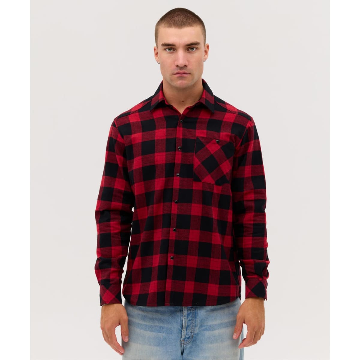 A men's button-up shirt featuring a red and black checked pattern, with a front pocket and a logo.