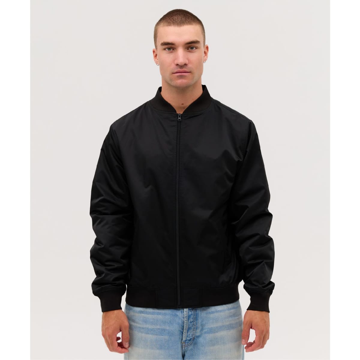 A black bomber jacket with a zip front and ribbed cuffs, worn by a model against a plain background.