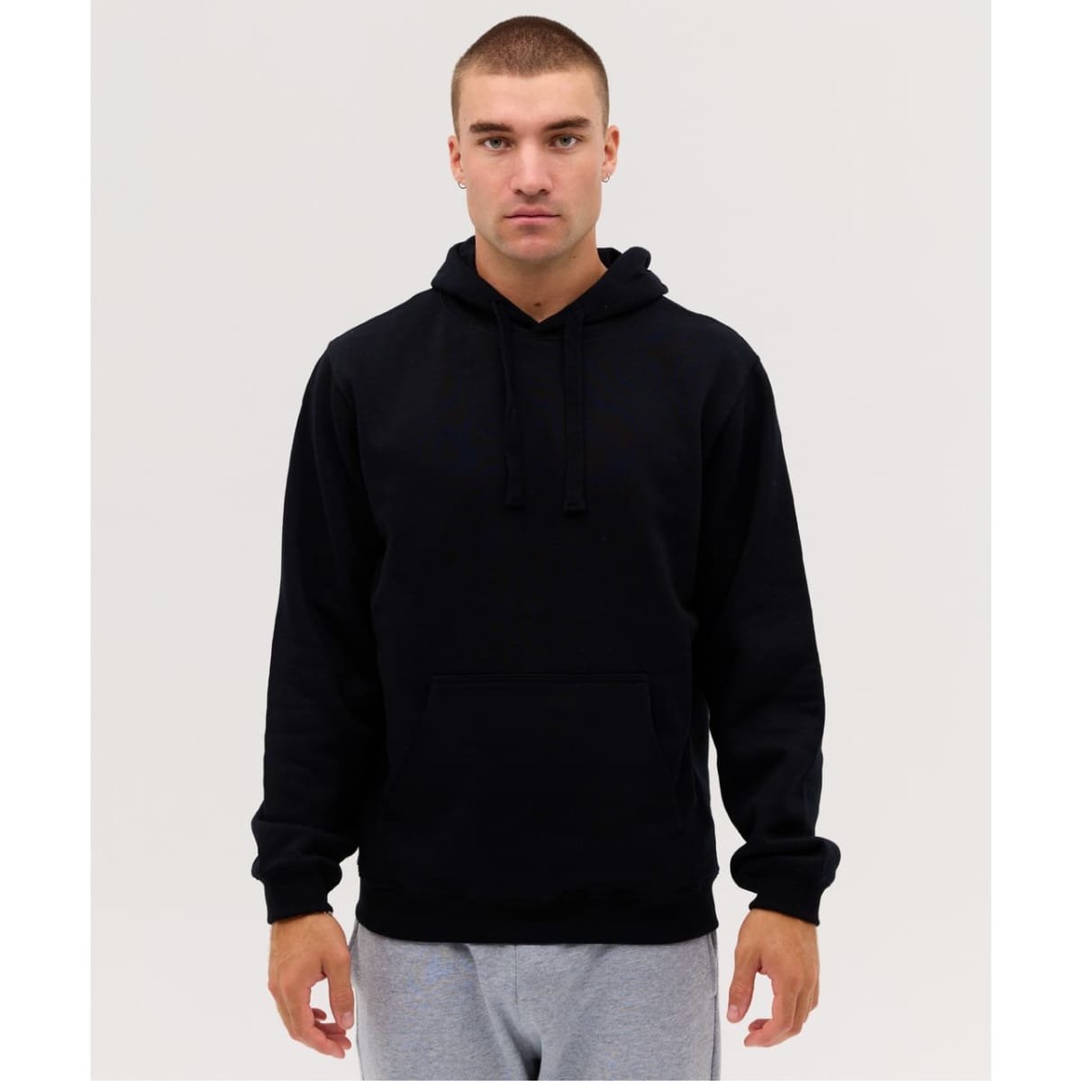 A black hoodie with a kangaroo pocket and drawstring hood, displayed on a model against a plain backdrop.