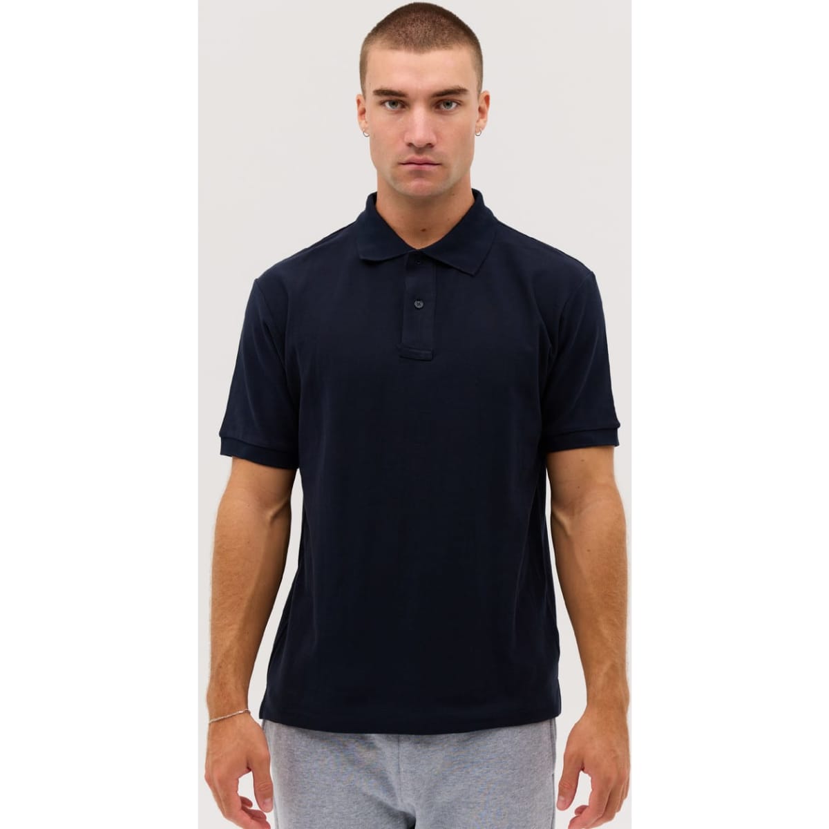 A navy blue polo shirt with a collar and short sleeves, featuring a logo on the chest.