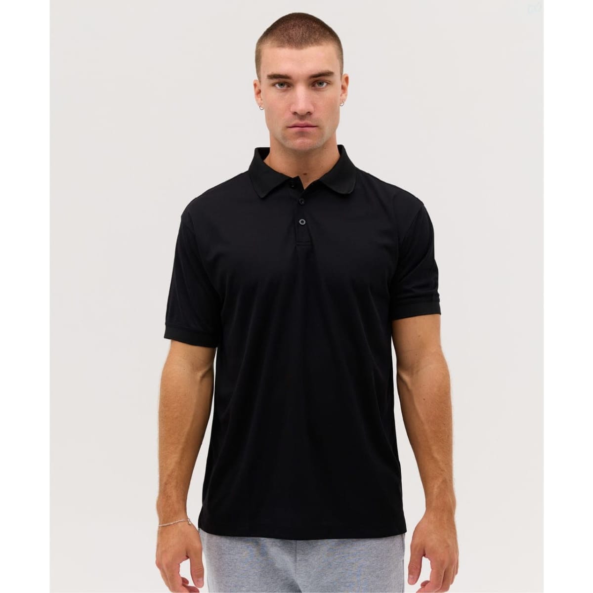 A black polo shirt with short sleeves, featuring a collar and a logo.