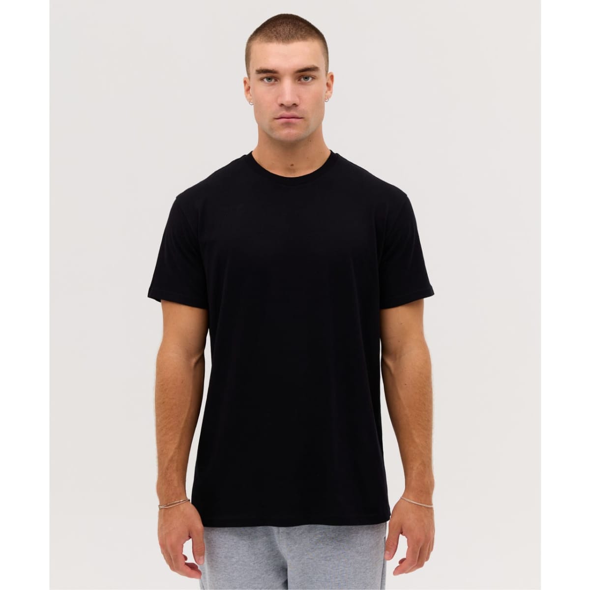 A plain black t-shirt featuring short sleeves and a round neckline, presented on a male model.