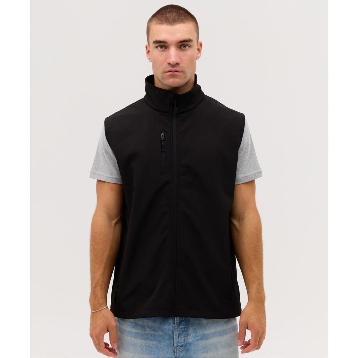 A black softshell vest with a zip front, featuring a chest pocket, worn over a grey short-sleeve shirt.