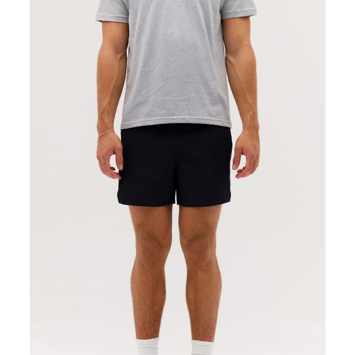 Running shorts in navy blue, featuring a minimalist design. Model wears a grey T-shirt for a casual look.