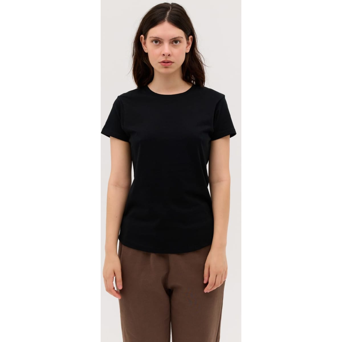 A black women's essential tee, featuring short sleeves and a round neckline, displayed on a model.