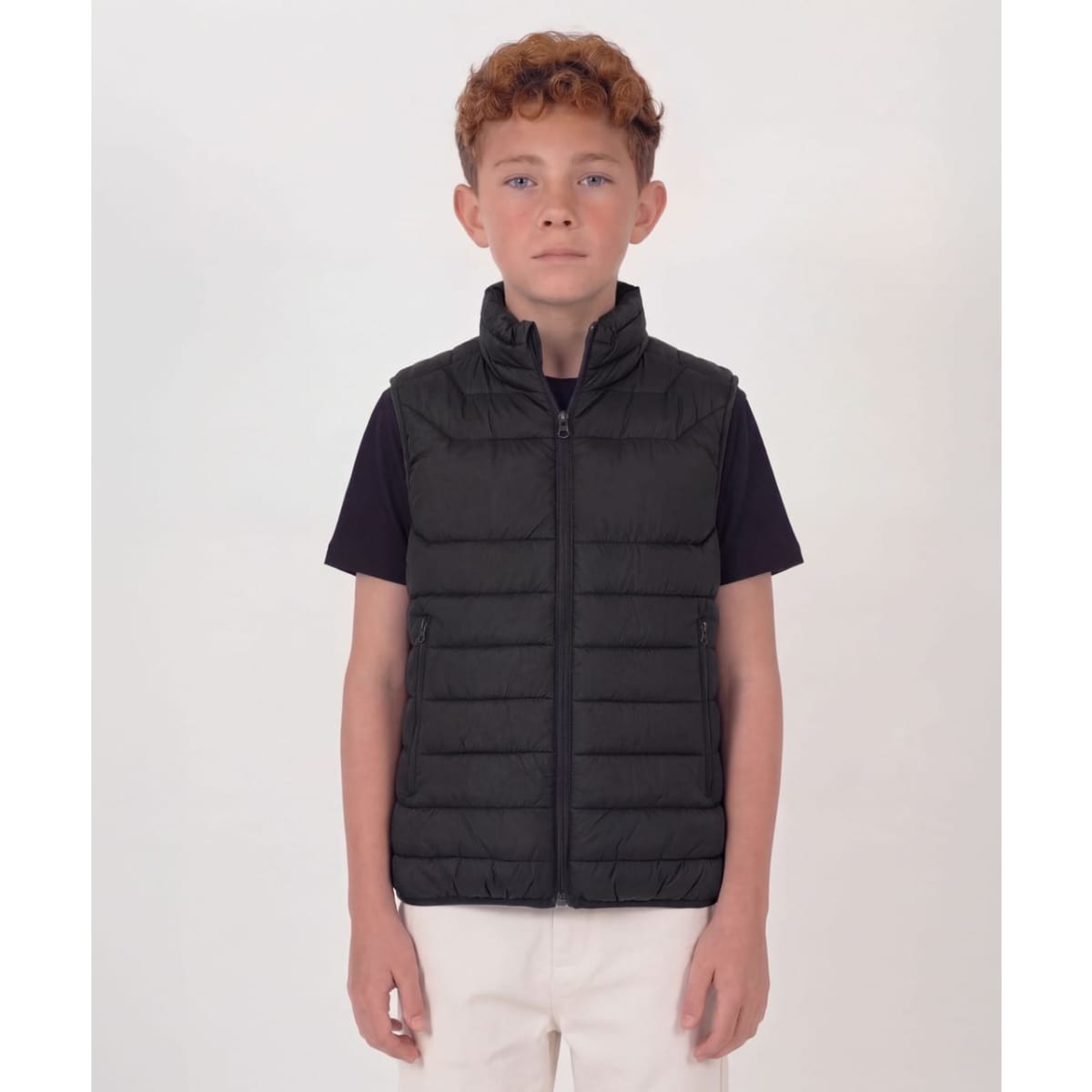A youth black puffer vest with a zip front and two side pockets, featuring a logo on one side.