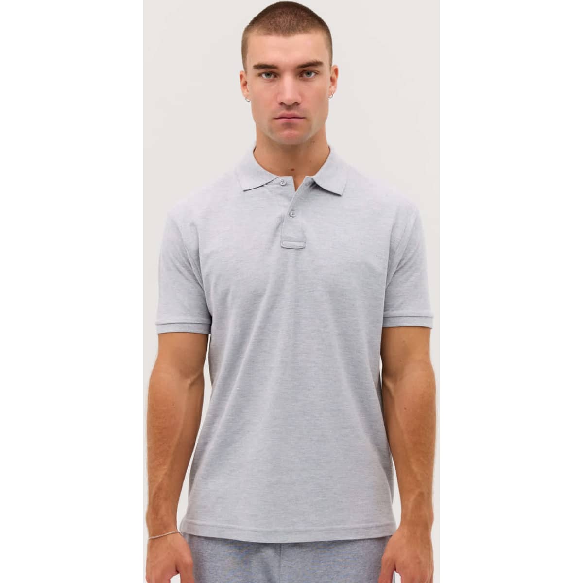A grey polo shirt with a collar, featuring short sleeves and a logo on the front.