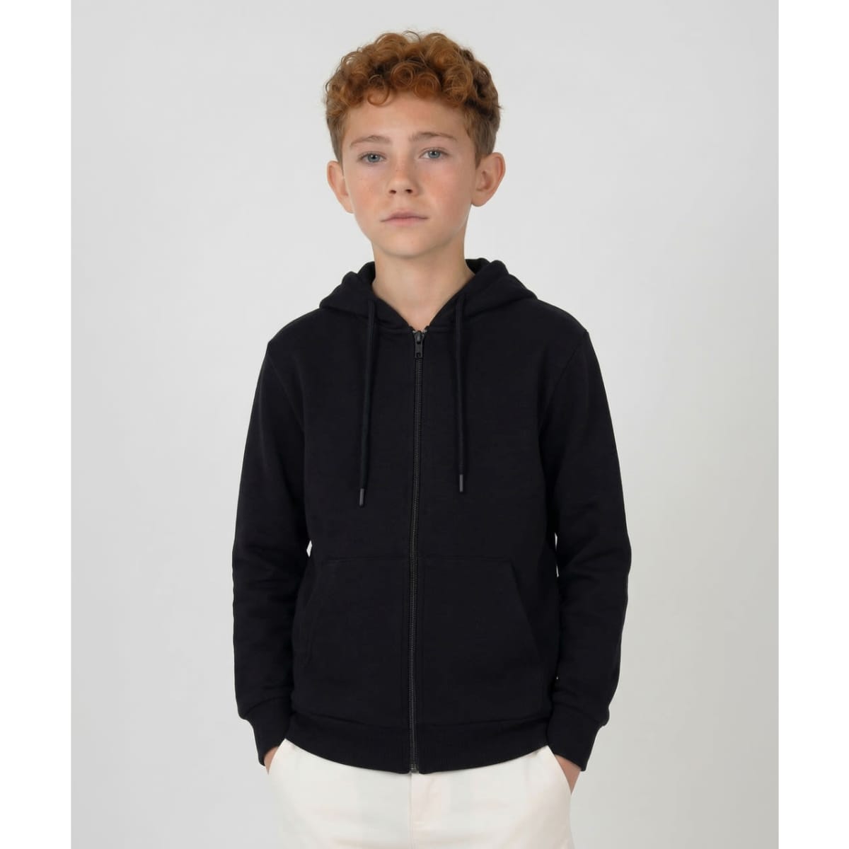 A black zip hoodie with a hood, featuring a front zipper and side pockets, modelled by a young boy.