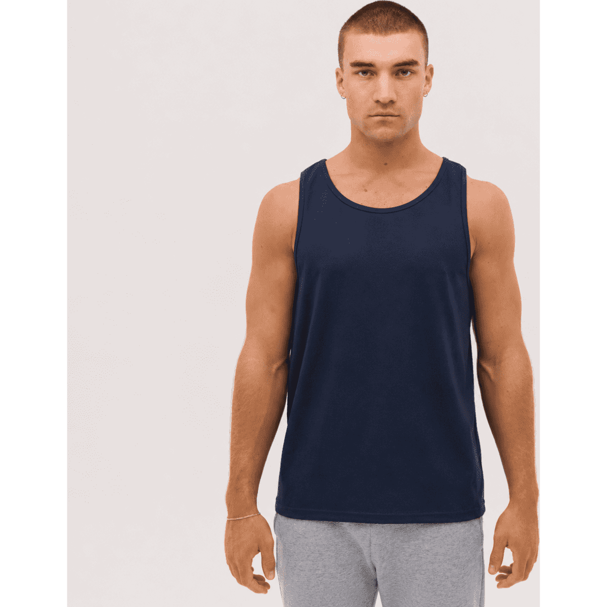 A navy singlet is displayed on a model, featuring a simple design and a branded logo.