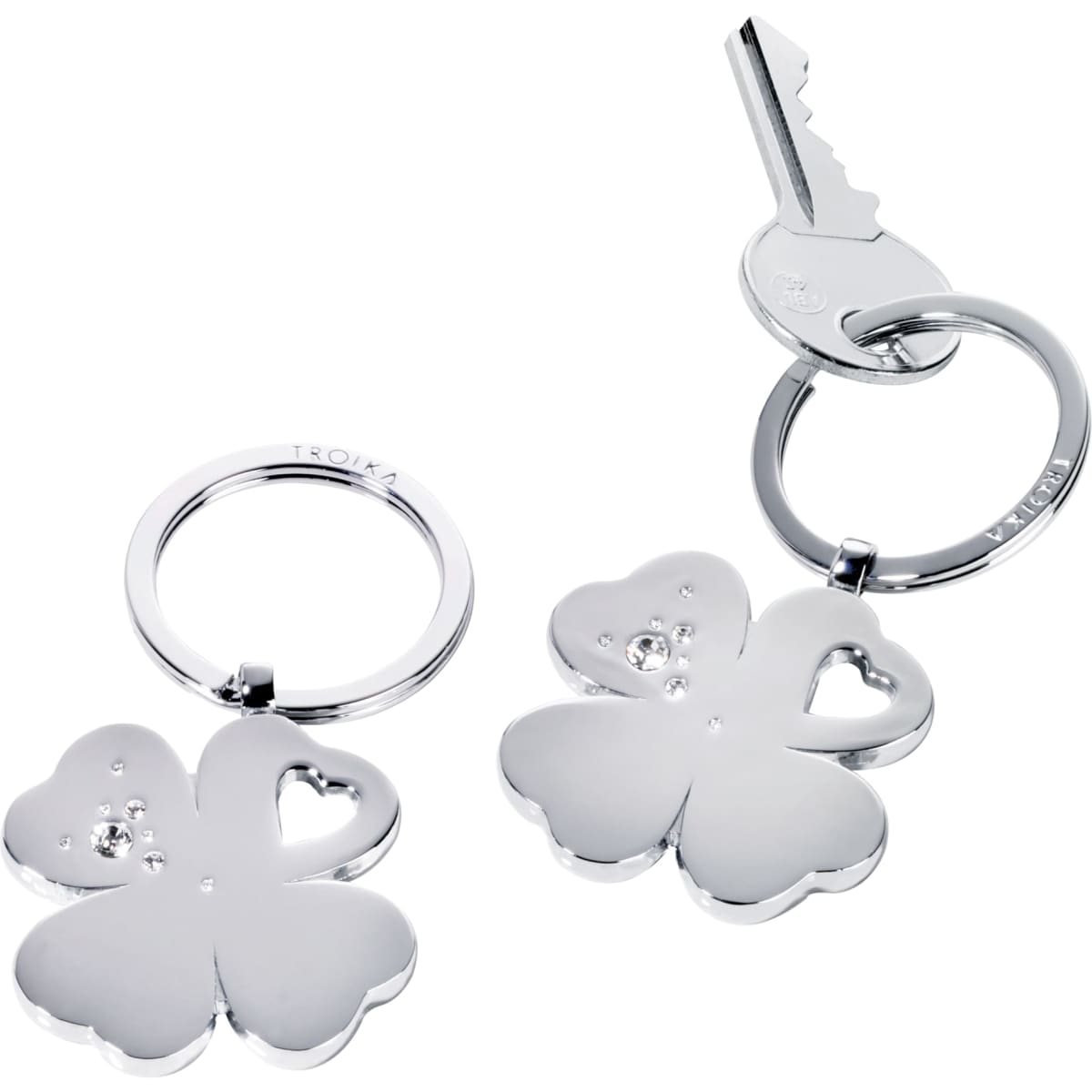 A keychain featuring a silver clover design with heart-shaped cutouts and decorative elements, attached to a key.