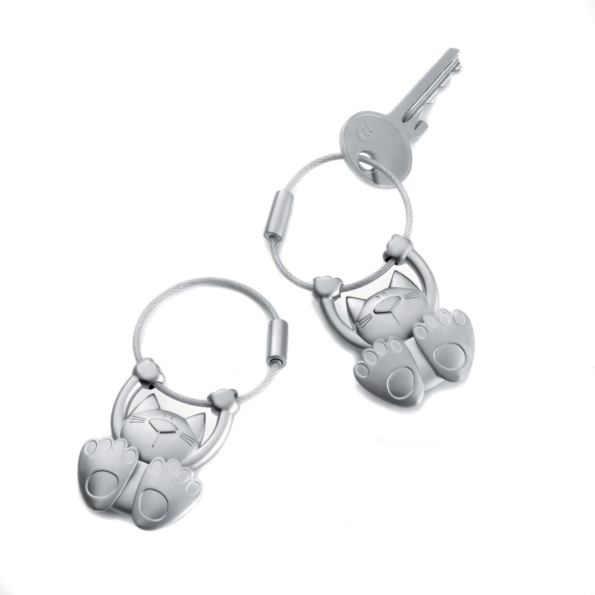 A keyring featuring a playful cat design in silver, with detailed paw prints and a loop for attaching keys.