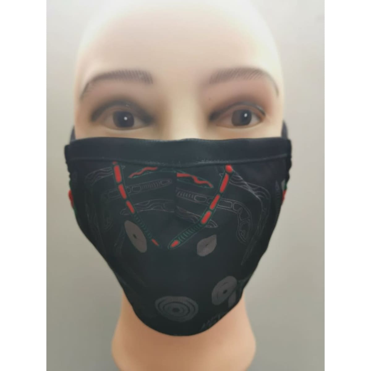 An Aboriginal art mask displayed on a mannequin, featuring intricate designs in black, red, and grey.