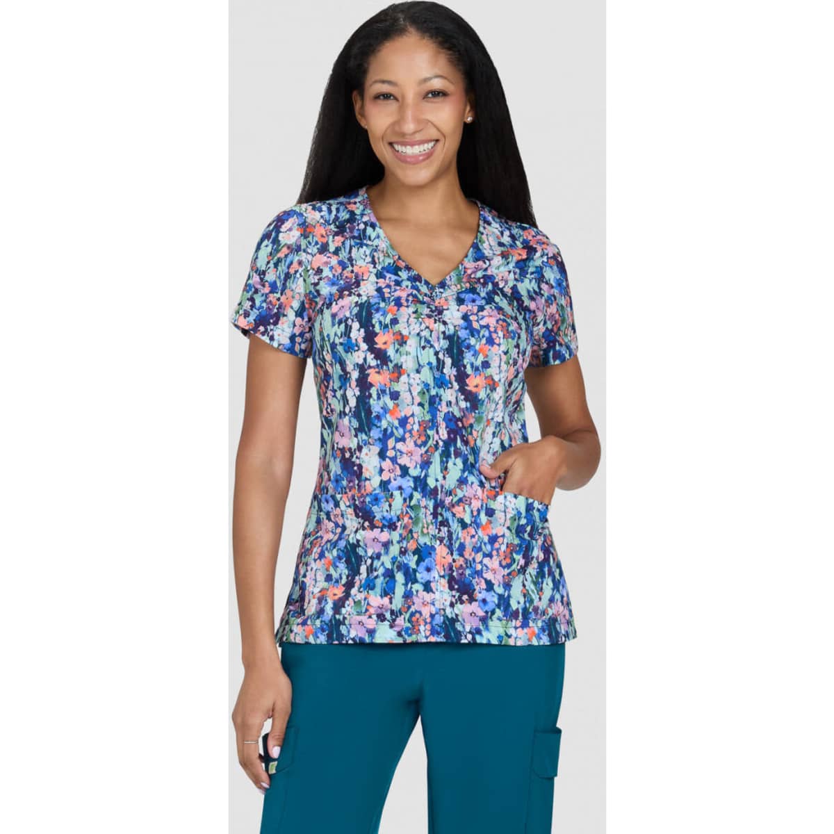 A floral print scrub top in vibrant colours, featuring a V-neck and short sleeves, with a pocket on the side.