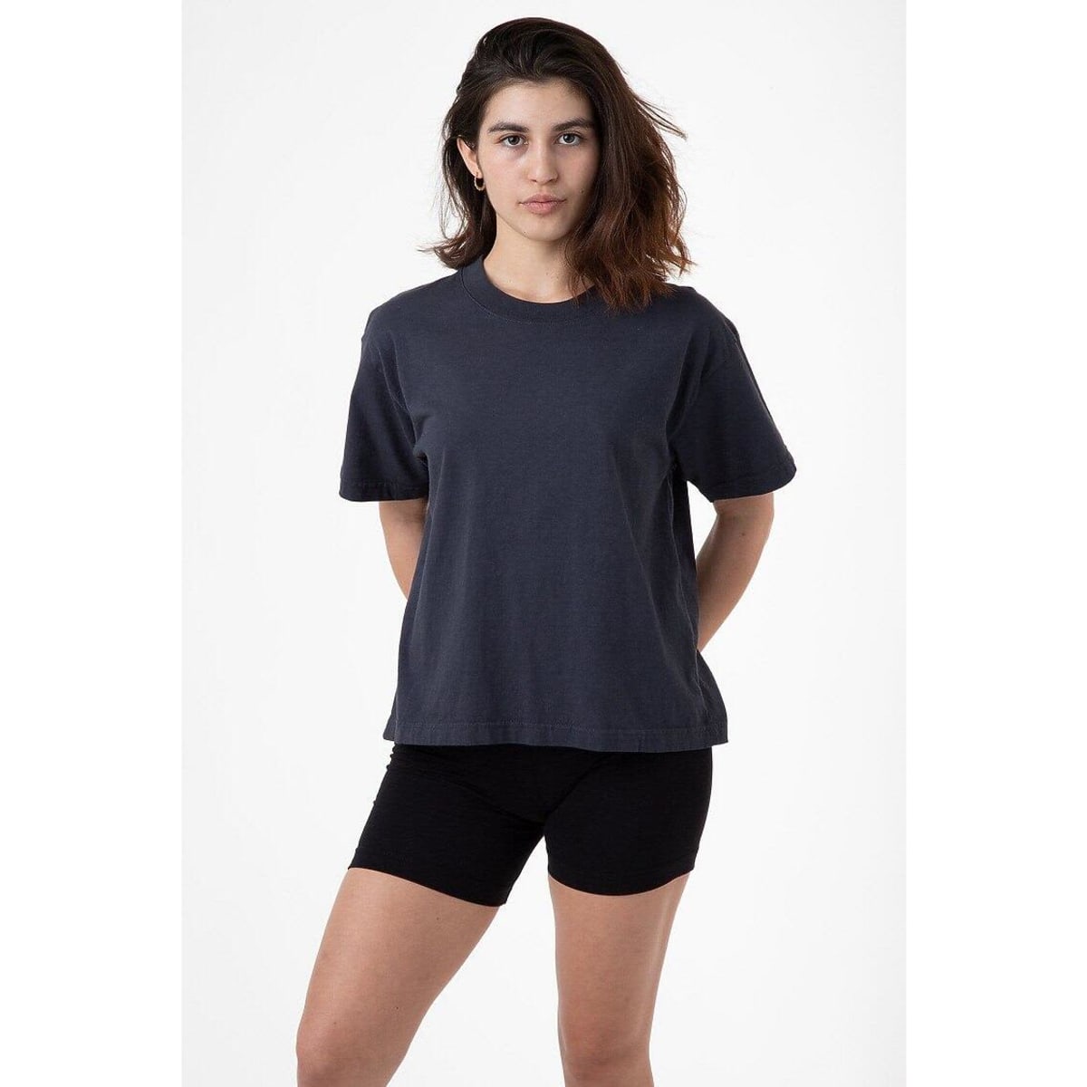 A model stands wearing a charcoal garment dye wide tee and black shorts, showcasing a relaxed fit and casual style.