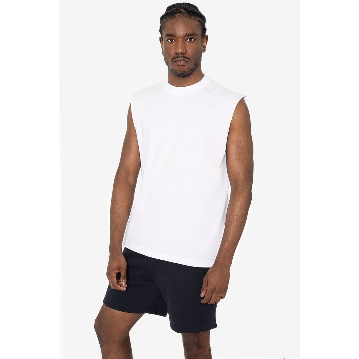 A sleeveless white tee displayed on a model, paired with black shorts. The shirt features a logo.