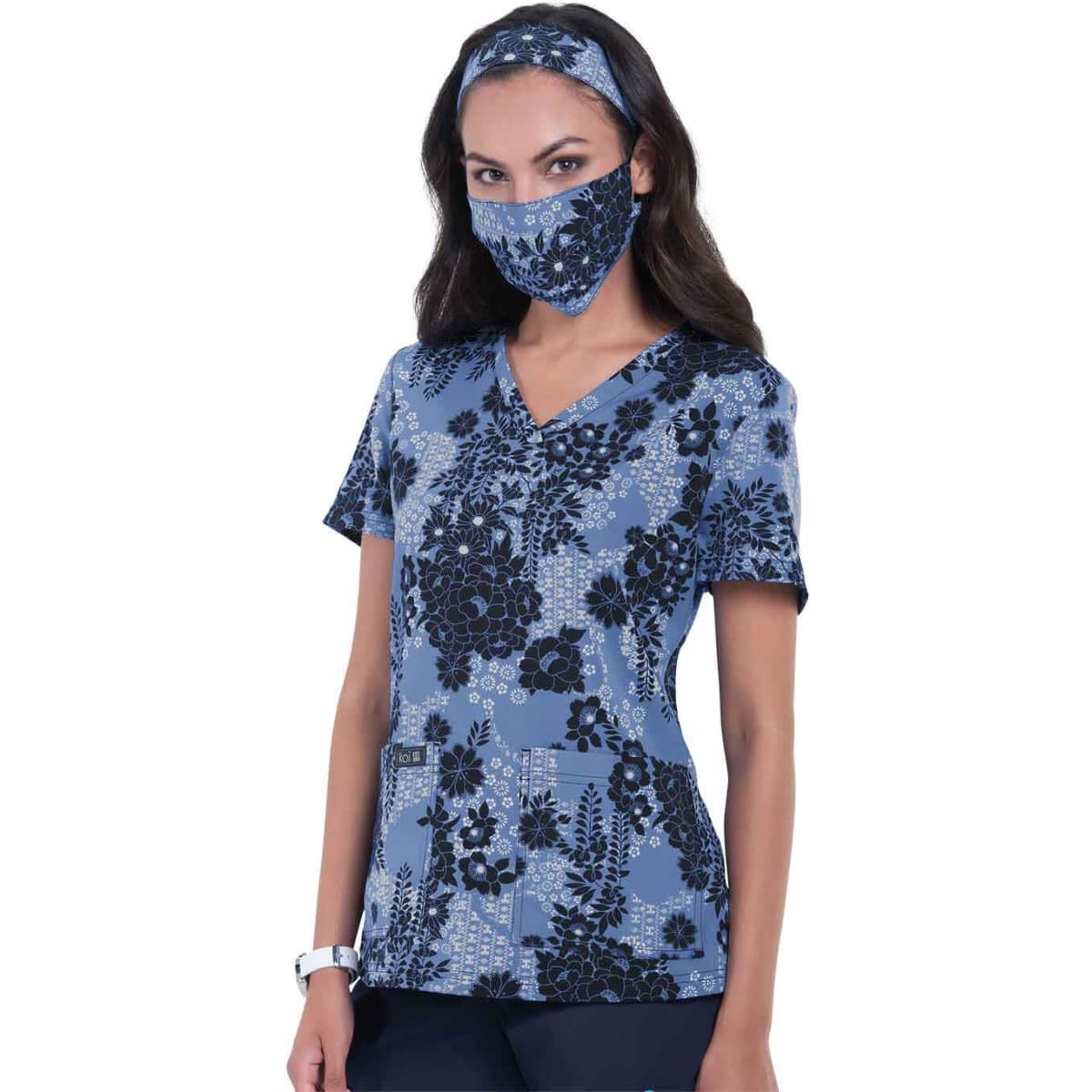 A floral print top in blue with matching face mask and headband, featuring a v-neck and pockets.