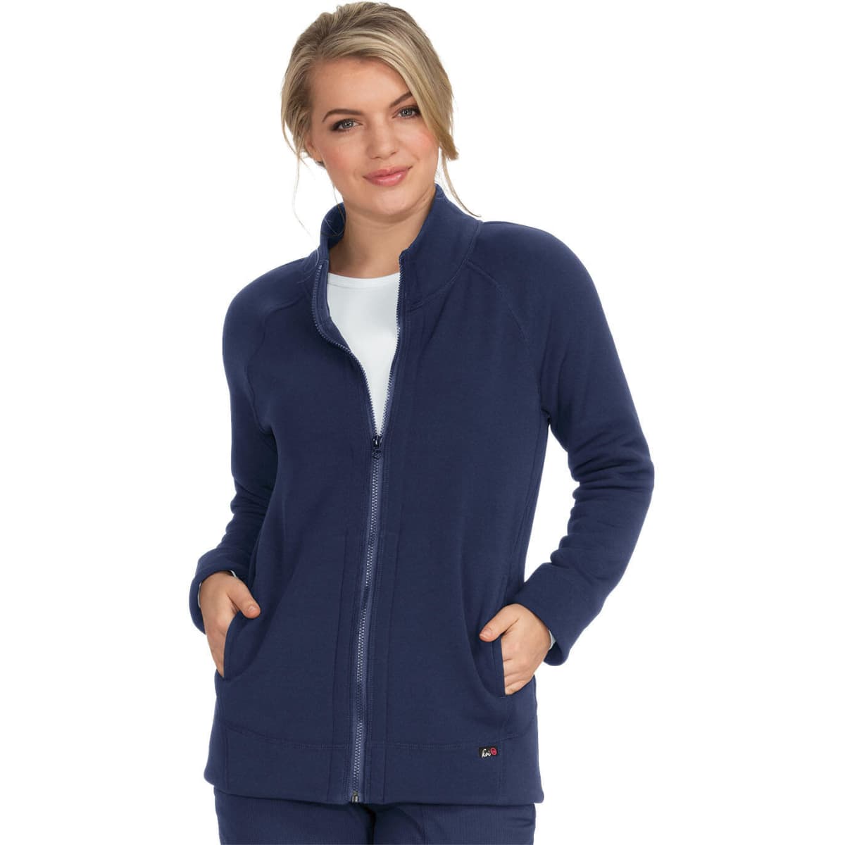 A navy blue wellness jacket with a zip front and pockets, worn by a woman standing confidently.