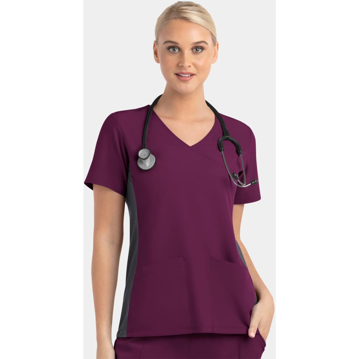 A mock wrap top in burgundy with grey contrast panels and a logo, worn by a model with a stethoscope.