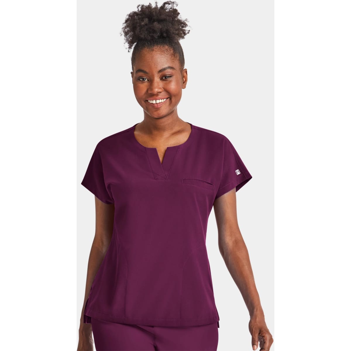 A women's notched neck dolman top in burgundy, featuring short sleeves and a chest pocket. The top has a logo.