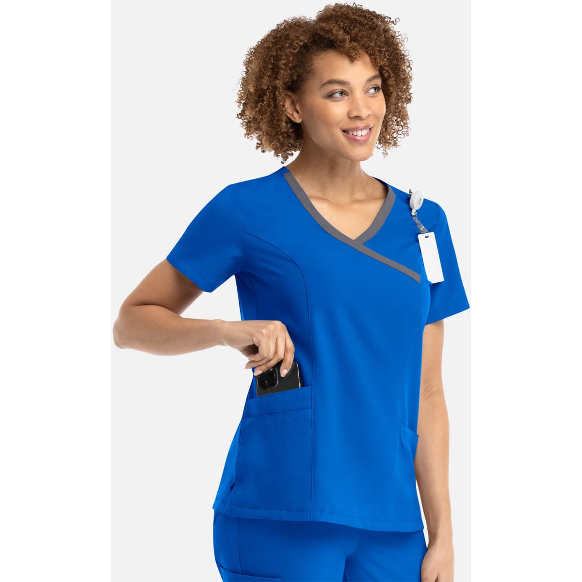 A women's mock wrap top in vibrant blue with contrast grey trim and pockets, featuring a logo.