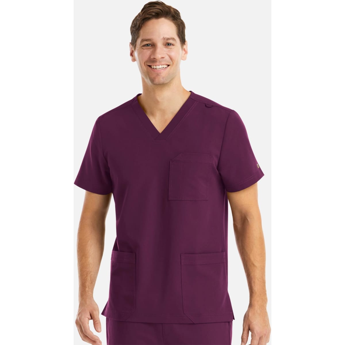 A man wearing a purple v-neck scrub top with three pockets, featuring a logo.