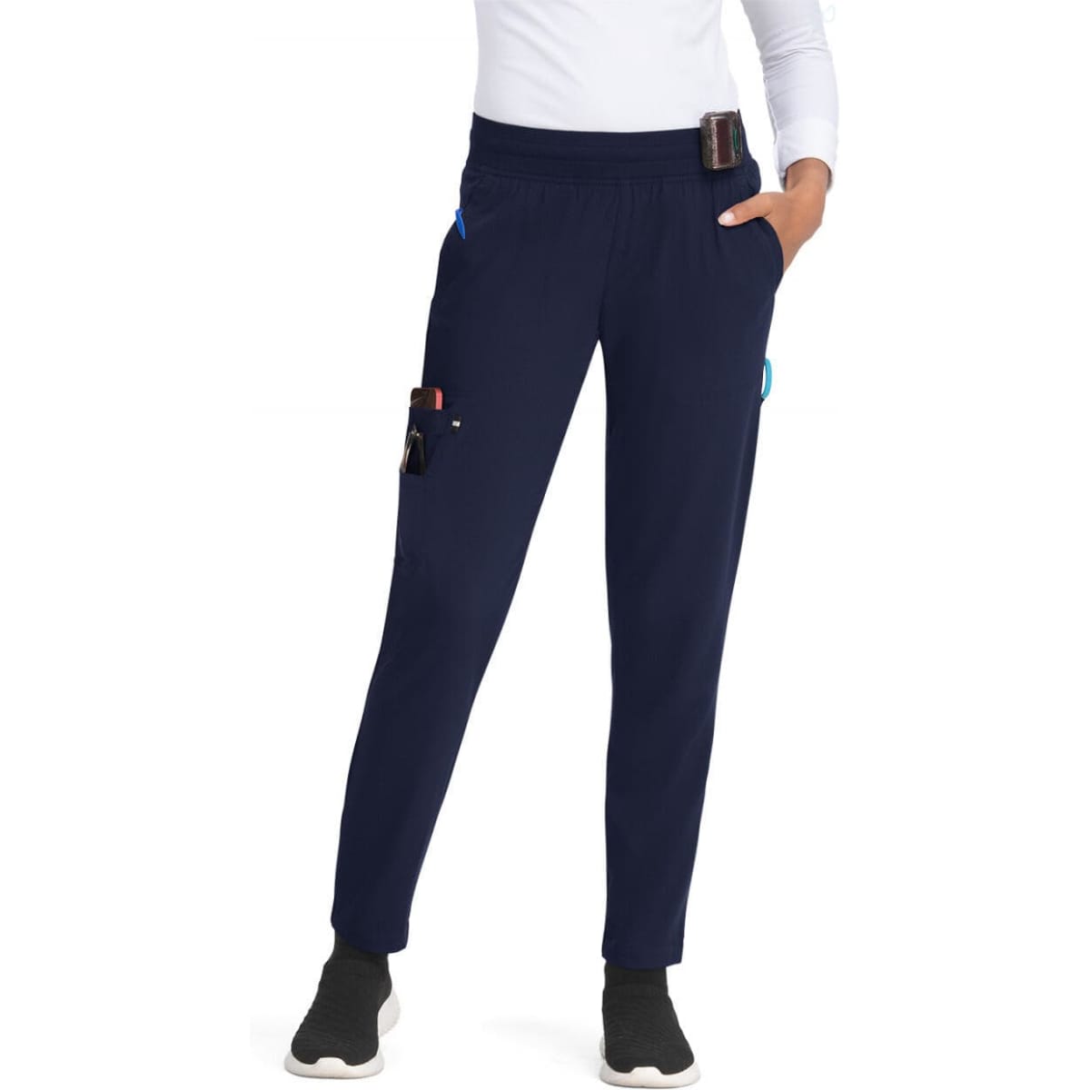 A pair of navy joggers with pockets, featuring a fitted design and elastic waistband. The model is wearing them with a white top.
