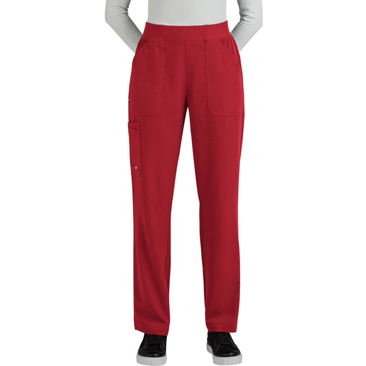 A pair of red boot cut pants features multiple pockets and a comfortable waistband. The model stands with hands in pockets.