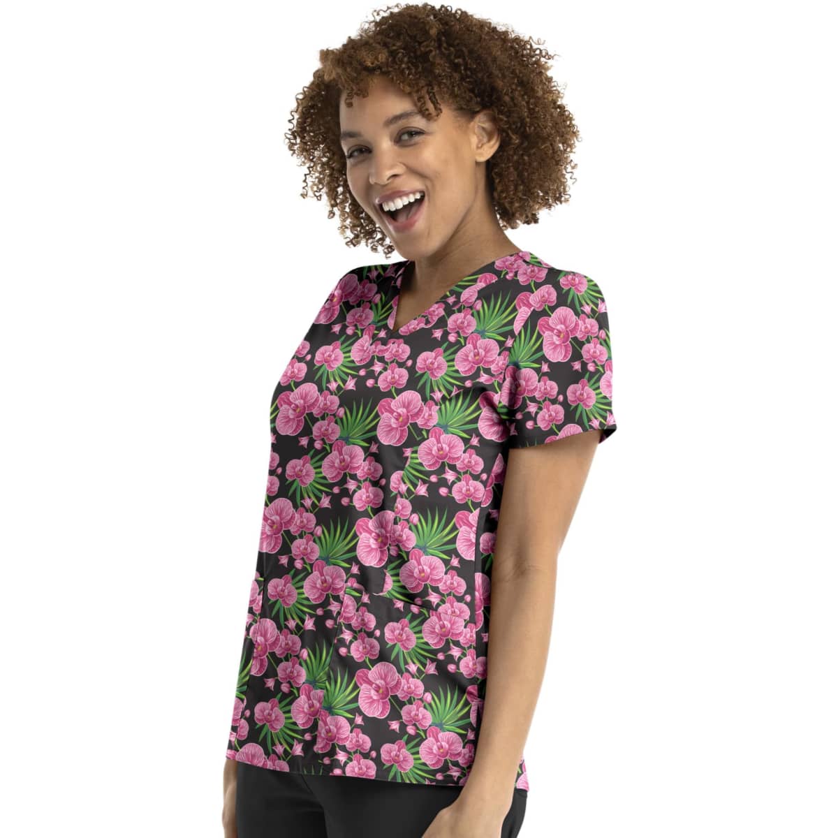 A woman smiles while wearing a vibrant pink floral V-neck print top against a black background. The top features a floral pattern.