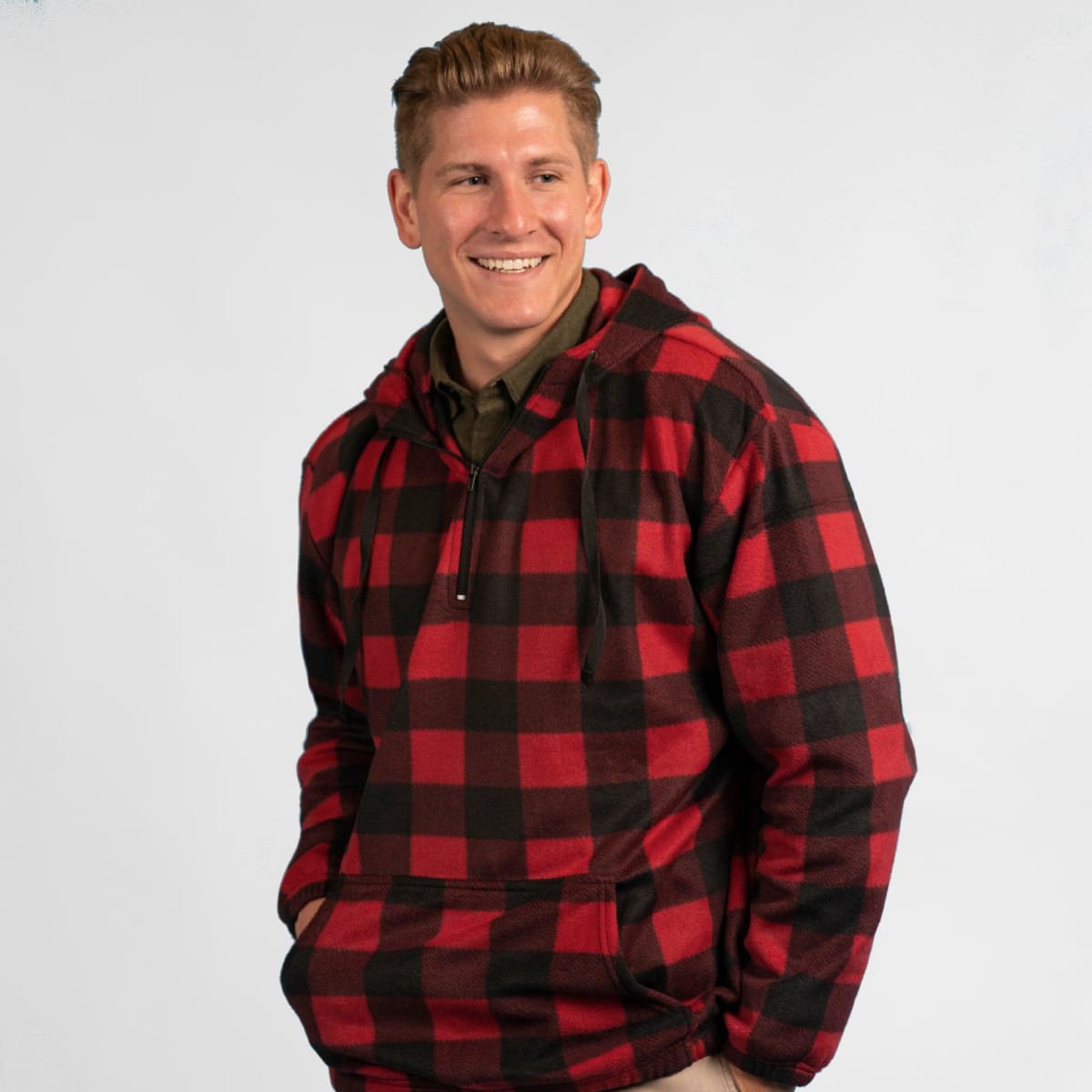 A red and black checkered 1/4 zip polar fleece hoodie worn by a smiling man. Features a front pocket and a logo.
