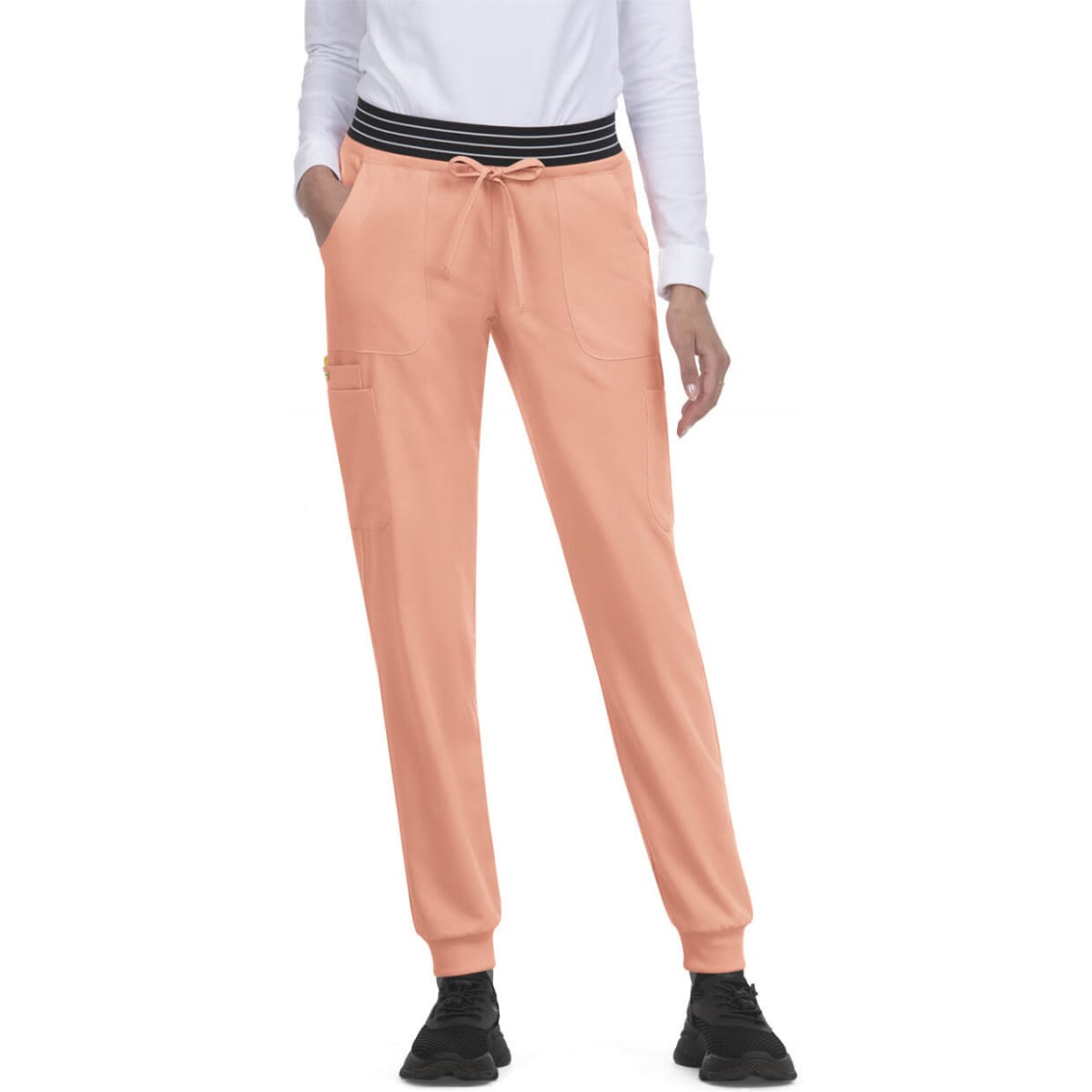 A pair of peach jogger pants with a black striped waistband and side pockets.