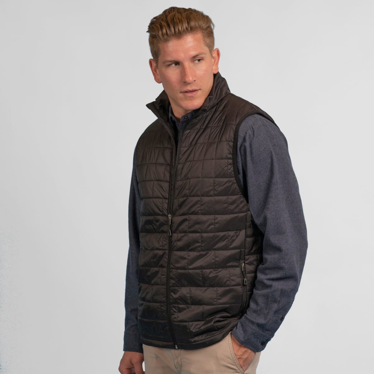 A quilted puffer vest in black, featuring a zip front and a simple design with a logo.