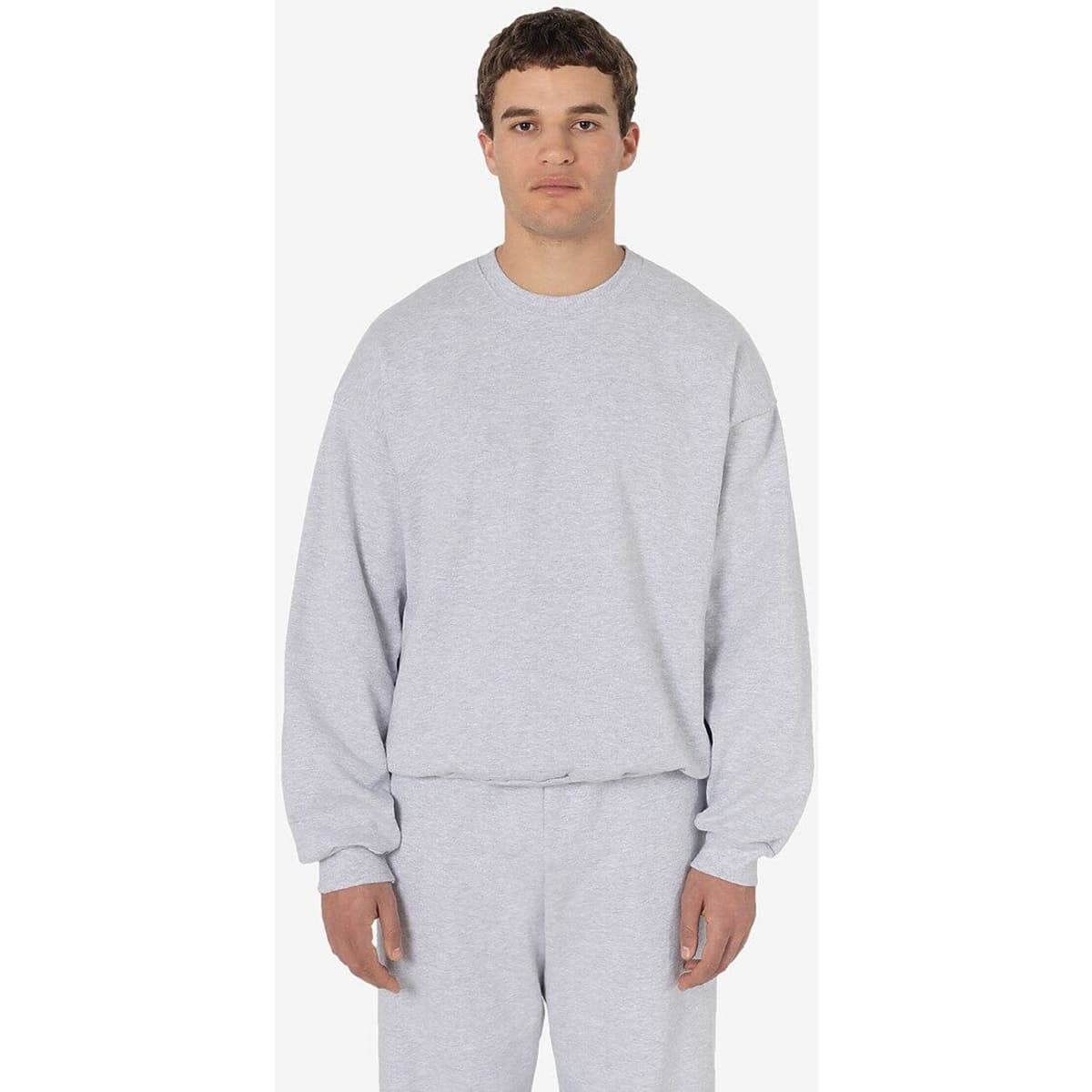 A grey heavy fleece pullover with long sleeves, displayed on a model. The product has a logo.