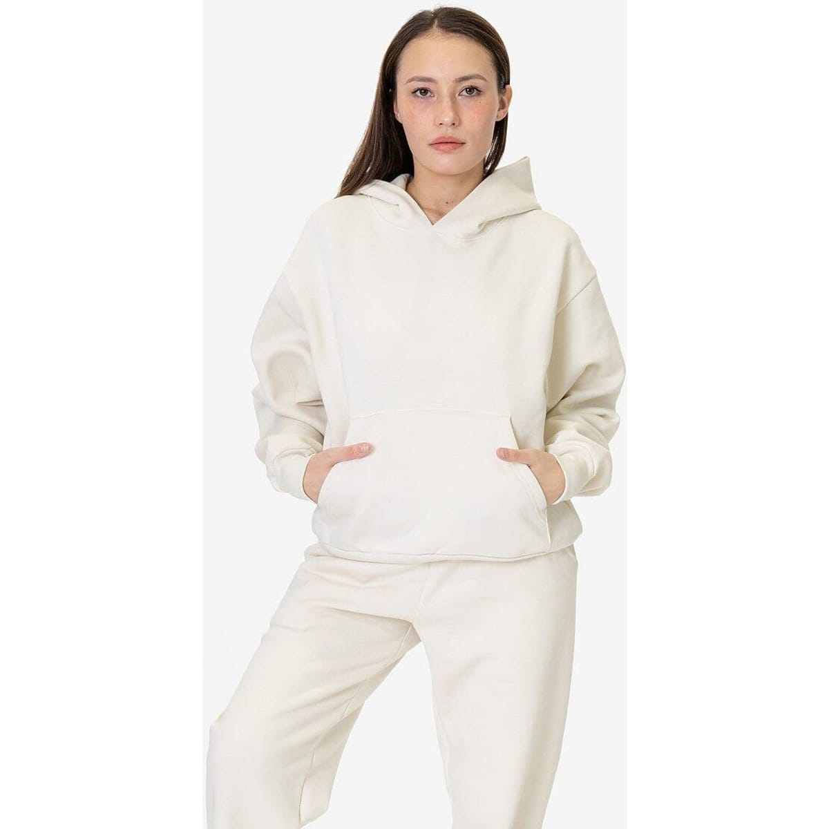 A model wearing a cream-coloured mineral wash fleece wide hoodie, featuring a hood and front pockets.