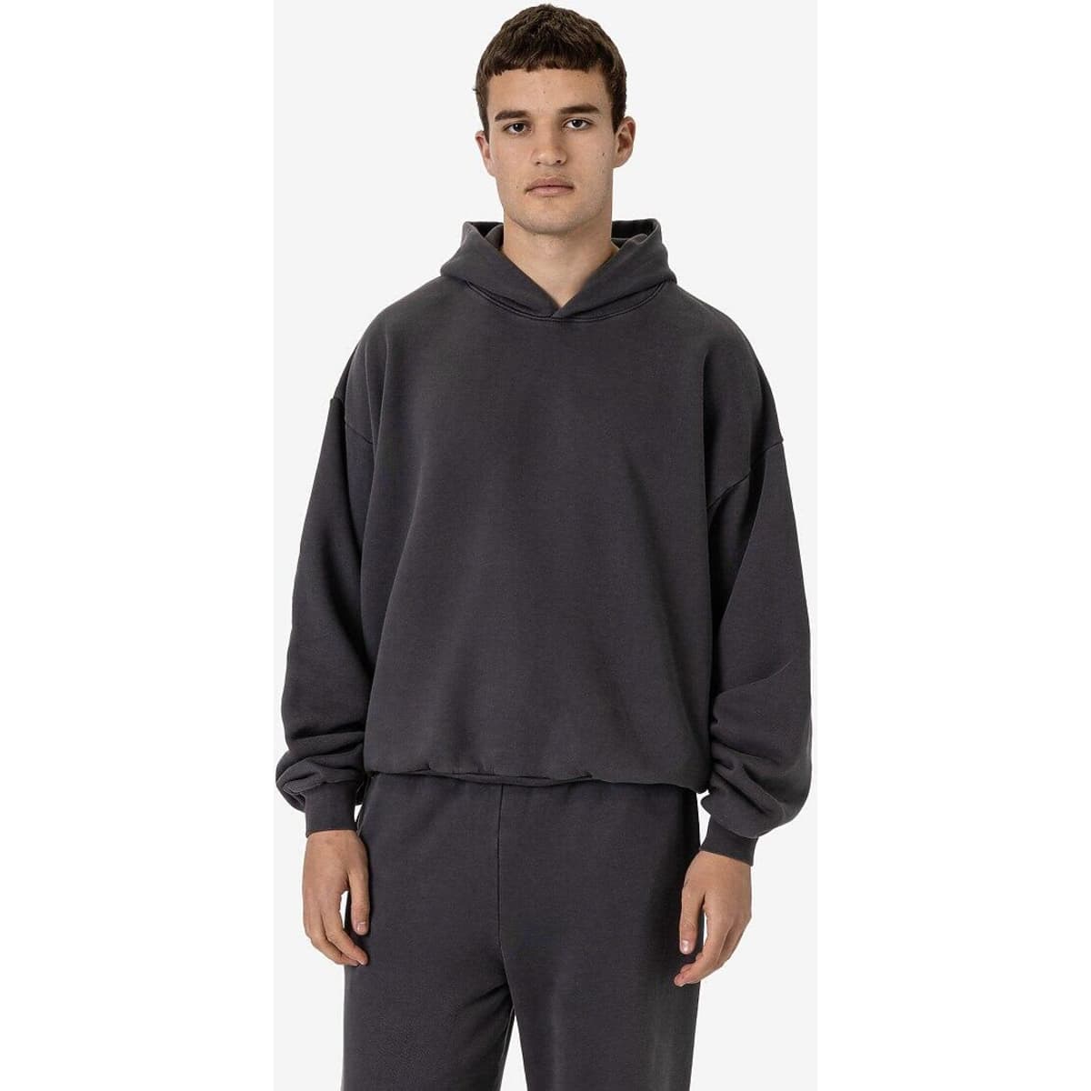 A dark grey garment dye plush fleece pullover hoodie with a hood, featuring a relaxed fit and long sleeves.