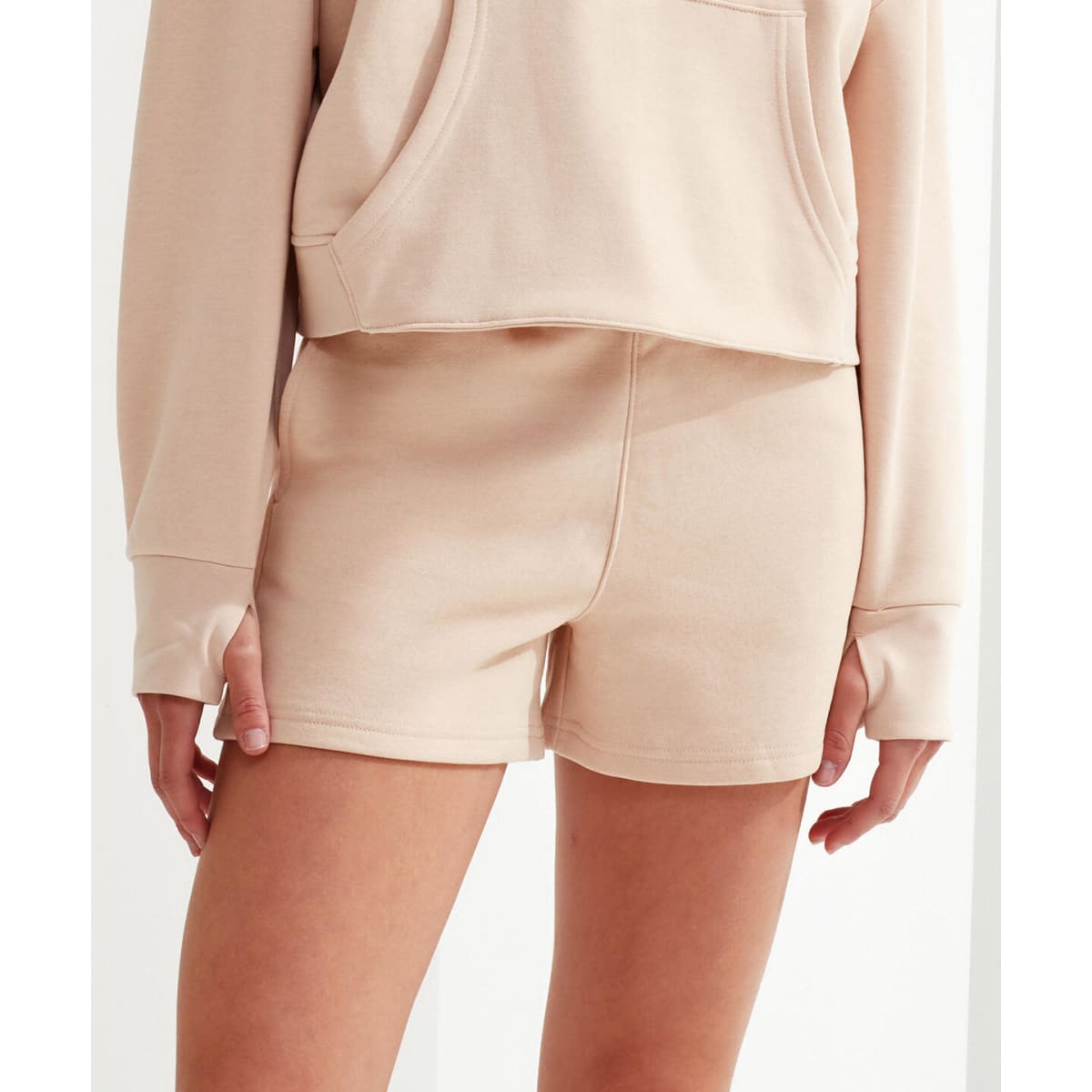 A pair of beige jogger shorts with a relaxed fit, featuring side pockets and a smooth fabric finish.