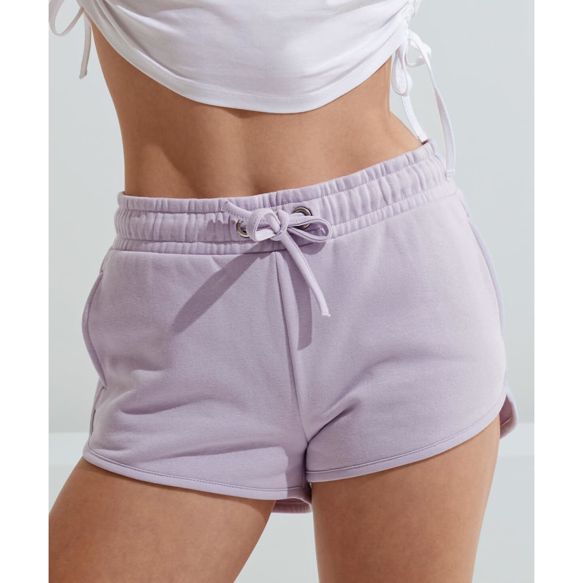 Lavender shorts with an elastic waistband and drawstring. Features a logo on the side. Perfect for casual wear.