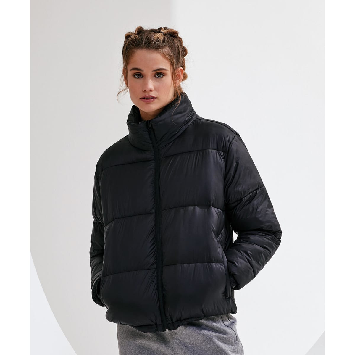 A black padded jacket is displayed on a model, featuring a high collar and a quilted design.