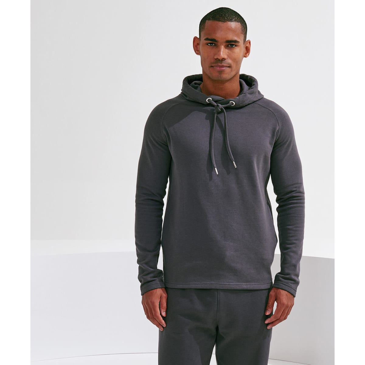 A dark grey hoodie with a drawstring hood, worn by a male model, features long sleeves and a fitted design.