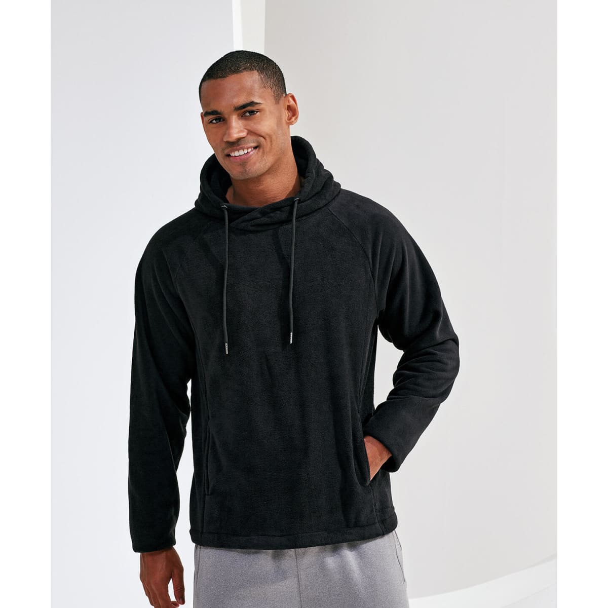 A black microfleece hoodie featuring a hood and front pockets, worn by a smiling man.
