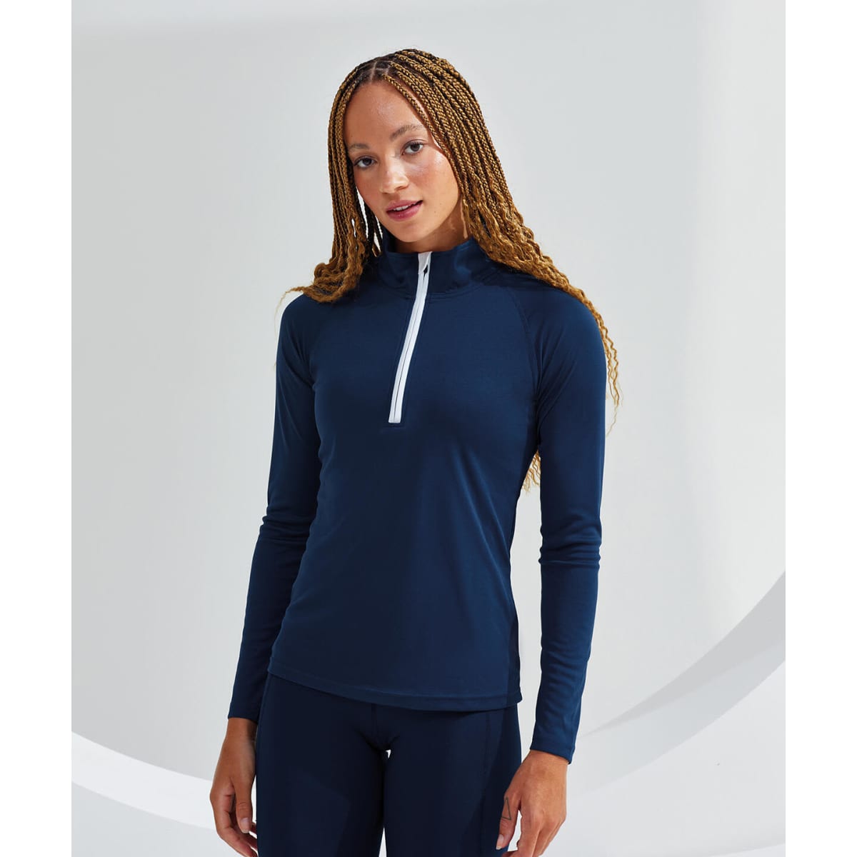 A navy long sleeve performance 1/4 zip top featuring a white zipper and a fitted design. It has a logo on it.