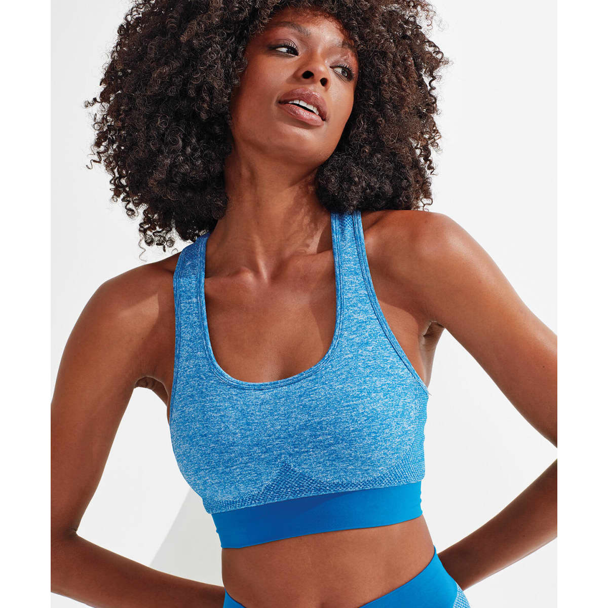 A blue sport bra with a seamless design and a contrasting blue band, featuring a logo.